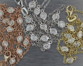 May include: Three delicate necklaces with round diamond accents. The necklaces are made of gold, rose gold, and silver chains.