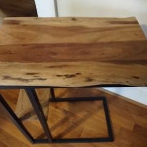 May include: A rectangular wooden side table with a natural wood grain finish. The table is supported by a black metal frame. The tabletop measures approximately 24 inches long and 16 inches wide.