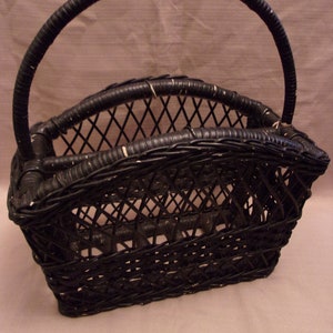 May include: Black wicker magazine holder with a woven design and a single handle.