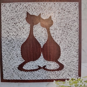 Puede incluir: Una taza de cerámica blanca con un asa negra y el texto "But First, Coffee" en negro, con una fuente de estilo manuscrito. La taza está sobre una superficie blanca.