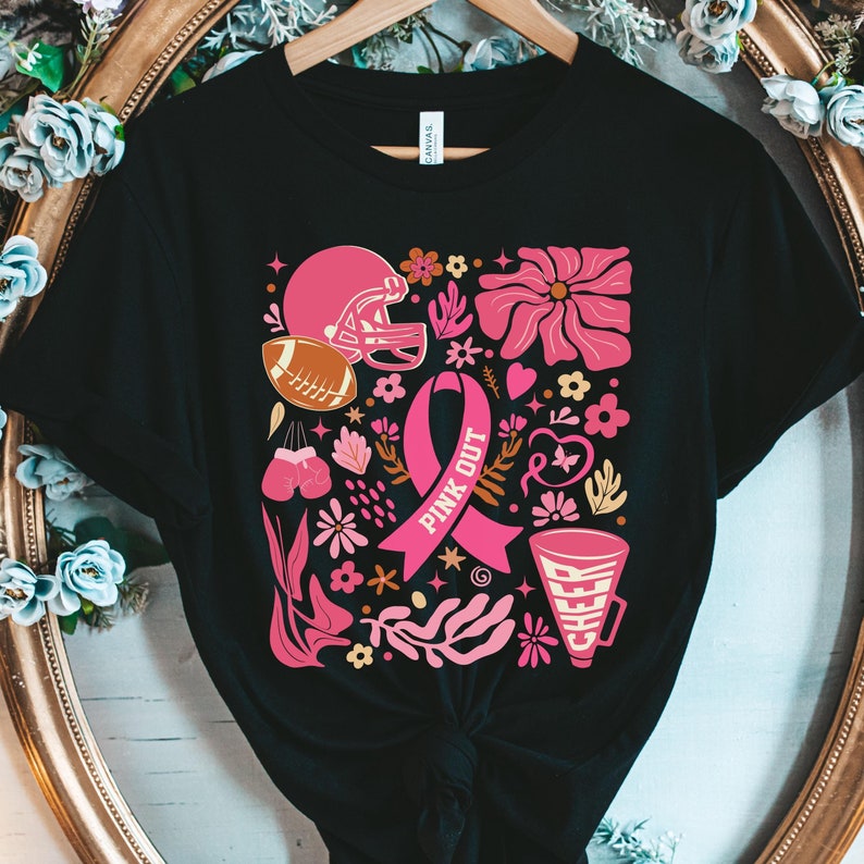 May include: A black t-shirt with a pink ribbon, football helmet, boxing gloves, and a megaphone with the words 'Pink Out' and 'Cheer' on it. The design is surrounded by pink and yellow flowers.