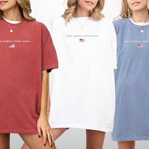 May include: Three oversized t-shirts in red, white, and blue. Each shirt has the text "MAKE AMERICA THINK AGAIN" above a small American flag graphic. The shirts are short-sleeved and have a relaxed fit.