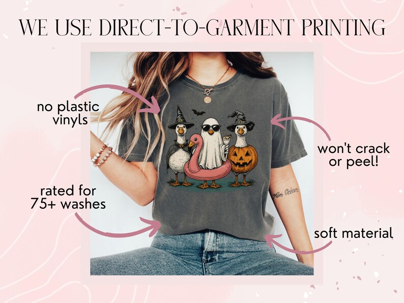 May include: Dark gray t-shirt featuring a Halloween-themed graphic of three ducks dressed as a witch, a ghost, and a jack-o'-lantern. The shirt has the text "WE USE DIRECT-TO-GARMENT PRINTING" and is rated for 75+ washes.