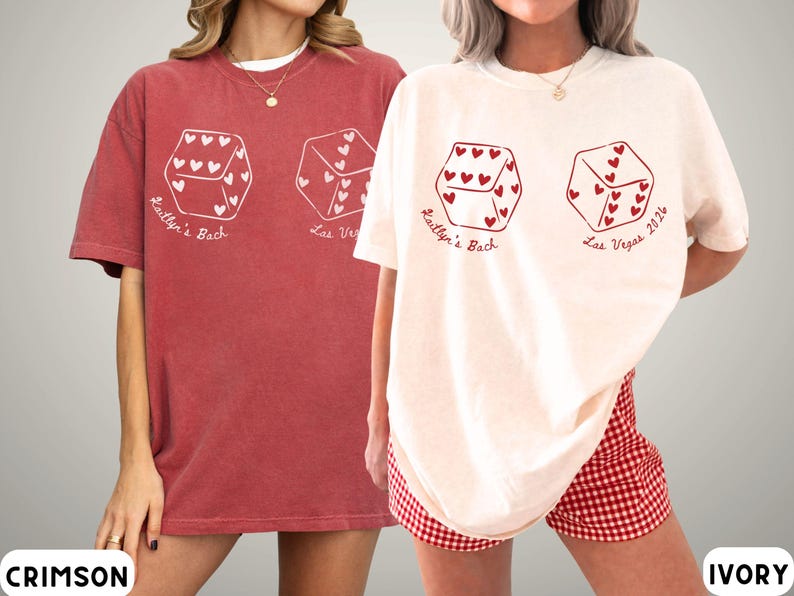 May include: Crimson and ivory-colored t-shirts with a dice graphic. Each die has heart-shaped pips and text that reads "Kaitlyn's Bach" and "Las Vegas 2024". The shirts are oversized and have a casual style.