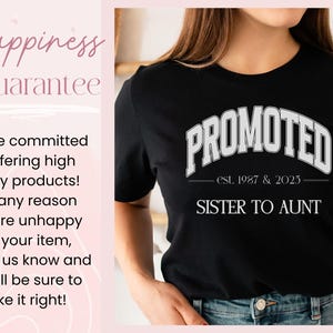 May include: Black t-shirt with the word "PROMOTED" in white block letters. Below the word "PROMOTED" is the text "est. 1987 & 2025" and the words "SISTER TO AUNT". The shirt is worn by a person.