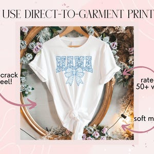 May include: White t-shirt with a blue floral design that says "MAMA" with a blue bow. The shirt is displayed on a gold frame with flowers. The text "WE USE DIRECT-TO-GARMENT PRINTING" is at the top of the image. The text "won't crack or peel!" is on the left side of the image. The text "rated for 50+ washes" is on the right side of the image. The text "soft material" is on the bottom right side of the image.
