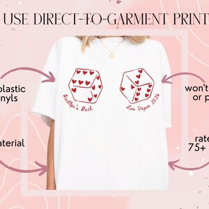 May include: White t-shirt featuring two dice with red heart details. The text "Kaitlyn's Bach Las Vegas 2026" is printed on the shirt. The image also includes text that says "WE USE DIRECT-TO-GARMENT PRINTING", "no plastic vinyls", "soft material", "won't crack or peel!", and "rated for 75+ washes".