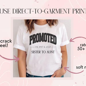 May include: White t-shirt with the word "PROMOTED" in a black, arched font. Below the word is "est. 1987 & 2023" and "SISTER TO AUNT". The shirt is made of a soft material and is rated for 50+ washes.