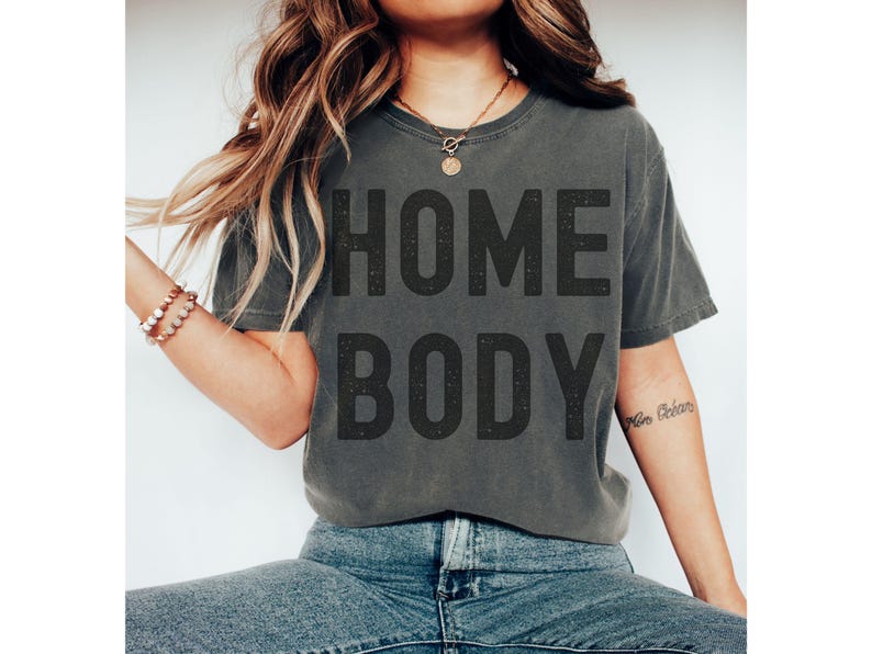 May include: A gray t-shirt with the text "HOME BODY" printed in black.