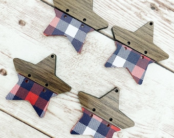 Op de afbeelding: Vier onafgewerkte houten sterren met rood en blauw geruit stof gelijmd aan de voorkant. De sterren zijn gescheiden en in een cirkel op een licht houten oppervlak gerangschikt.