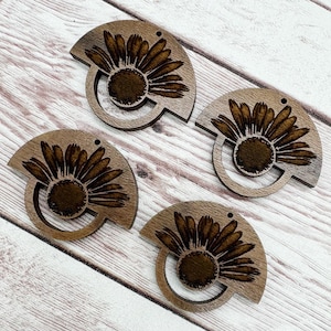 May include: Four wooden sunflower-shaped earrings. Each earring features a detailed sunflower design with a dark brown center and petals, set within a semi-circular frame. The earrings are made of light brown wood and have a small hole for hanging.