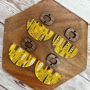 May include: Four pairs of yellow and black patterned half-circle earrings with wooden earring posts.