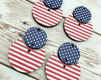 Op de afbeelding: Vier paar ronde houten oorbellen met een Amerikaans vlagontwerp. De oorbellen zijn gelaagd met een rood-wit gestreepte cirkel bovenop een blauwe cirkel met witte sterren.