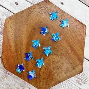 May include: A wooden hexagon-shaped tray with a blue and white patterned sea turtle design. The tray is decorated with ten sea turtles in various sizes and positions.
