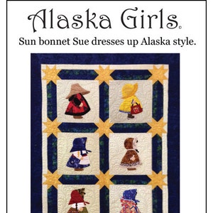 May include: A quilted wall hanging titled "Alaska Girls" featuring six blocks depicting figures in traditional Alaskan attire. The blocks are set against a cream background with a blue border and gold star accents. Text reads "Sun bonnet Sue dresses up Alaska style."