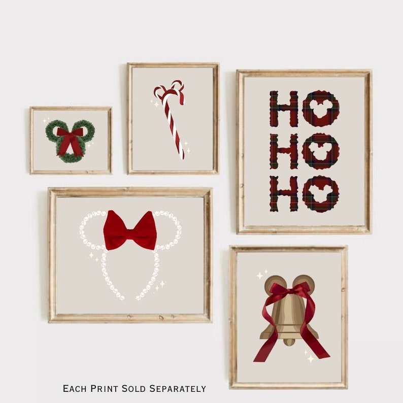 May include: A collection of framed Christmas-themed art prints. The prints feature festive designs including a candy cane, a Mickey Mouse-shaped wreath, a bell, and the word "HO HO HO" with Mickey Mouse silhouettes. Each print has a beige background.