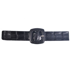 May include: A black leather belt with a square buckle. The belt has a crocodile-embossed pattern.