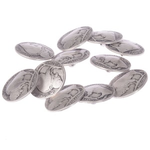 May include: A group of silver-coloured metal buttons with a design of a buffalo and the words "United States of America" and "Five Cents".
