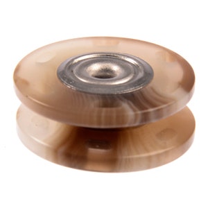 May include: A close-up of a brown and white plastic button with a silver metal center. The button has a raised edge and a smooth surface.