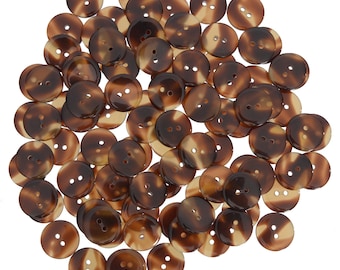 May include: A large pile of brown and tan plastic buttons with two holes each.