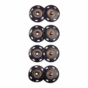 May include: Four sets of black snap fasteners with silver metal accents. Each set consists of two pieces, one with a raised button and the other with a recessed socket.