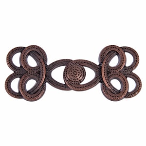 May include: A copper-toned metal toggle clasp with a decorative knot design. The clasp has two loops on each end and a central oval with a spiral design.