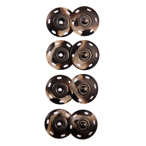 May include: Four sets of brown and white patterned snap buttons with metal centers. Each set consists of two buttons, one with a flat surface and one with a raised dome.