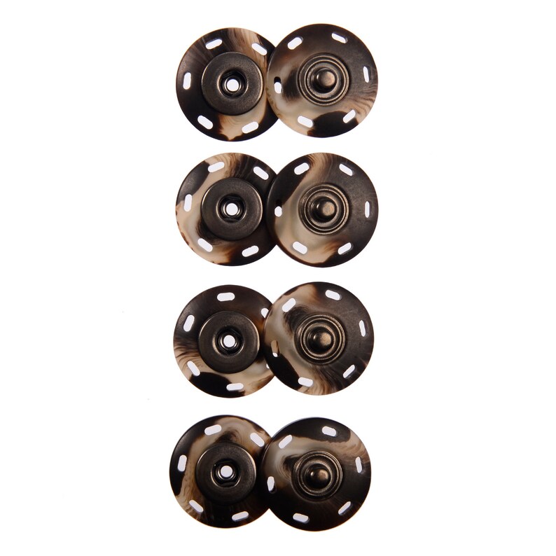 May include: Four sets of brown and white patterned snap buttons with metal centers. Each set consists of two buttons, one with a flat surface and one with a raised dome.