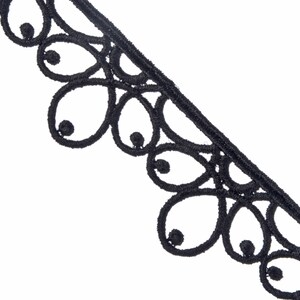 Può includere: Bordura in pizzo nero con bordo smerlato. La bordura presenta un motivo ripetuto di disegni a forma di goccia con piccoli accenti circolari. La bordura è realizzata in un materiale morbido e strutturato ed è su sfondo bianco.