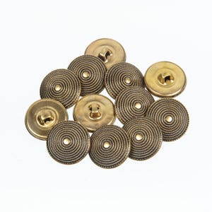 May include: A group of ten gold-colored buttons with a decorative, concentric circle design.