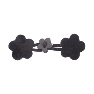 May include: Black fabric flower buttons connected by a black cord. The buttons are in the shape of a five-pointed flower.