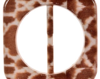 Puede incluir: Una hebilla de cinturón cuadrada con un diseño de estampado de jirafa marrón y blanco.