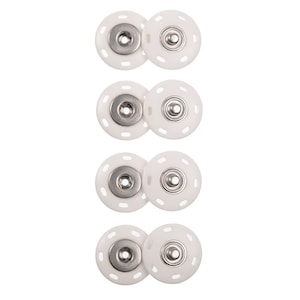May include: Four sets of white plastic snap fasteners with silver metal centers. Each set consists of two pieces, one with a raised center and one with a recessed center.