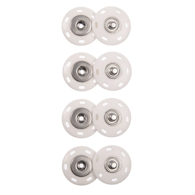 May include: Four sets of white plastic snap fasteners with silver metal centers. Each set consists of two pieces, one with a raised center and one with a recessed center.