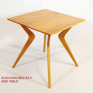 May include: A light wood side table with a square top and four angled legs. The table is made of solid wood and has a natural finish.