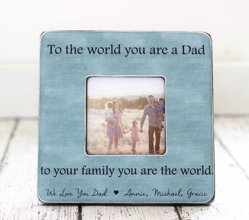 May include: Square, light blue picture frame with a family photo. The frame has the text "To the world you are a Dad, to your family you are the world." and "We Love You Dad Annie, Michael, Gracie."