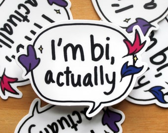 Peut inclure: Un autocollant blanc avec une bulle de dialogue qui dit "Je suis bi, en fait." L'autocollant a un motif floral violet, rouge et bleu autour de la bulle de dialogue.