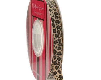 May include: A spool of brown and black leopard print ribbon with a pink and brown striped label that reads "Hair Bow Center - The Supply You Need".