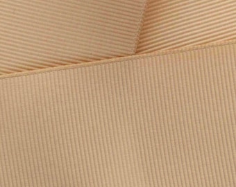 May include: A close-up of a beige grosgrain ribbon with a textured surface.