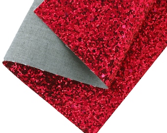 Op de afbeelding: Rode glitterstof met een zachte, grijze achterkant. De stof is dubbelgevouwen, waardoor beide kanten zichtbaar zijn.