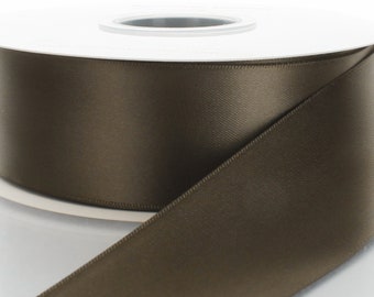 May include: A spool of brown satin ribbon. The ribbon is smooth and shiny.