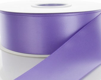 May include: A spool of lavender satin ribbon. The ribbon is smooth and shiny.