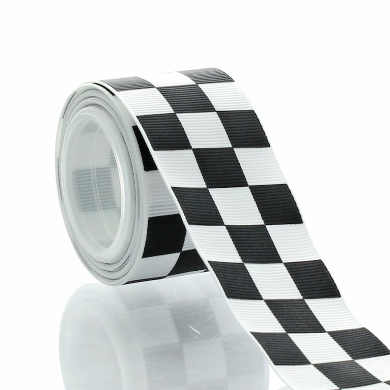 May include: A roll of black and white chequered ribbon. The ribbon is made of a satin-like material and is perfect for adding a touch of style to any project.