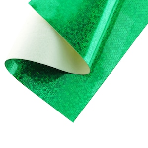 May include: Green iridescent craft paper with a white backing. The paper has a textured, glittery finish.