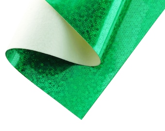 Może przedstawiać: Zielony, iryzujący papier do rękodzieła z białym podkładem. Papier ma fakturowaną, błyszczącą powierzchnię.