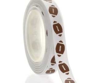 May include: A roll of white ribbon featuring a repeating pattern of brown American footballs. The ribbon is ideal for crafting, gift wrapping, and sports-themed decorations. The ribbon is rolled up, displaying the football design.