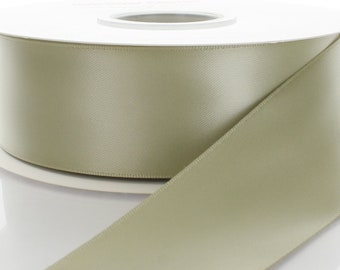 May include: A spool of sage green satin ribbon. The ribbon is rolled up on a white spool.