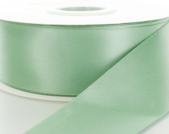 May include: A spool of sage green satin ribbon. The ribbon is smooth and shiny.