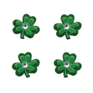 May include: Four green shamrock-shaped embellishments with a silver rhinestone in the center of each.