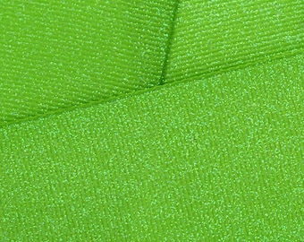 May include: Close-up of green glitter ribbon with a textured surface.